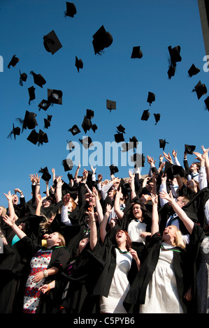 Eine Gruppe von Aberystwyth Universität Absolventen am Abschlusstag, werfen ihre Mützen in die Luft, UK Stockfoto