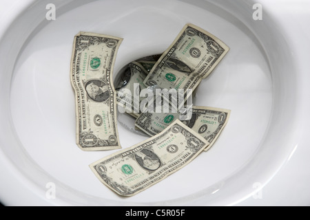 uns spülen Dollarnoten hinunter die Toilette Stockfoto