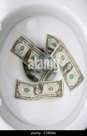 uns spülen Dollarnoten hinunter die Toilette Stockfoto