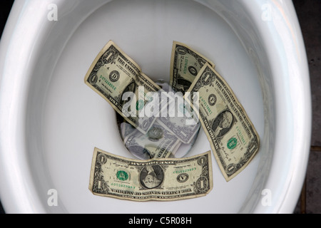 uns spülen Dollarnoten hinunter die Toilette Stockfoto