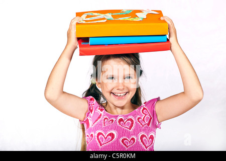 acht Jahre altes Mädchen hat Bücher auf dem Kopf Stockfoto