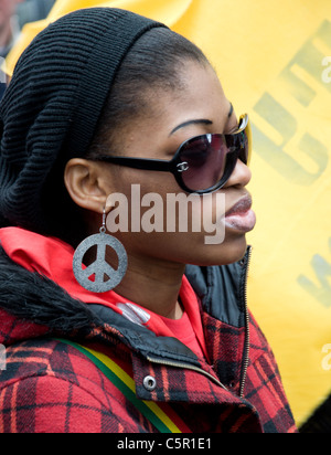 Schwarze Frau mit Sonnenbrille und große CND Ohrringe bei G20-März in London Stockfoto
