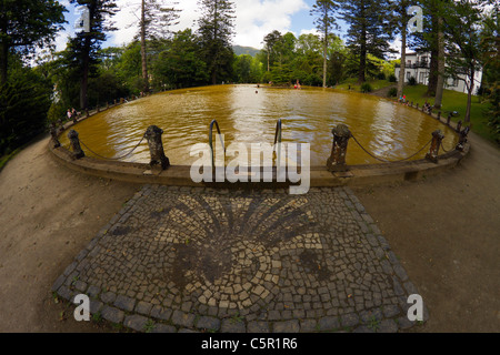 Menschen im goldenen Wasser des ursprünglichen Fountain of Youth, einer heißen Quelle im Park Terra Nostra, Furnas Dorf, Azoren. Stockfoto