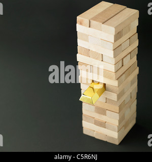 Jenga-Blöcken und einem goldenen block Stockfoto