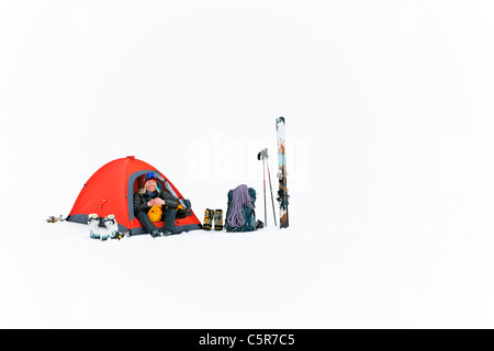 Ein glücklicher Camper camping auf Schnee. Stockfoto