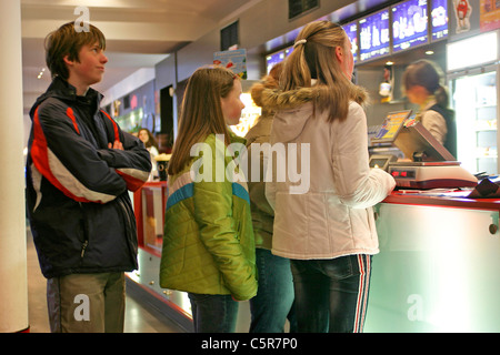 Jugendliche, die Schlange, um Süßigkeiten in einem Kino zu bekommen, bevor der Film beginnt Stockfoto