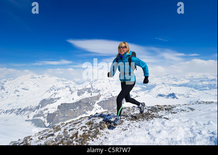 Frauen genießen einen Lauf über einen verschneiten alpinen Gebirge. Stockfoto