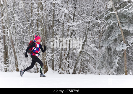 Ein Jogger läuft durch einen frostigen Wald. Stockfoto