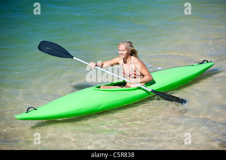 Eine junge Frau, eine Kajak zu paddeln. Stockfoto