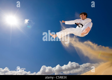 Schwarzgurt Kampfkünstler in Angriff fliegen. Stockfoto