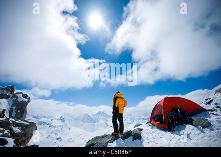 Ein Bergsteiger blickt auf schneebedeckten Berge. Stockfoto