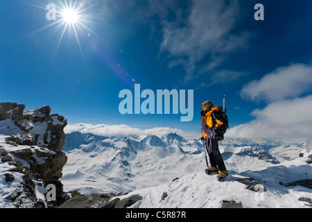 Ein Bergsteiger über die Gipfel und Wolken befasst sich mit der tollen Aussicht. Stockfoto