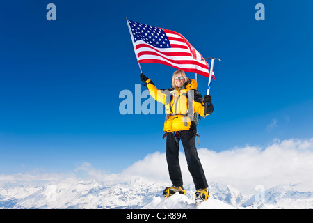 Ein Bergsteiger feiert auf hohe Berggipfel. Stockfoto