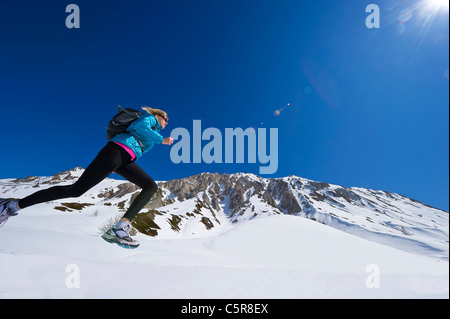 Jogger laufen durch verschneite Berge Stockfoto