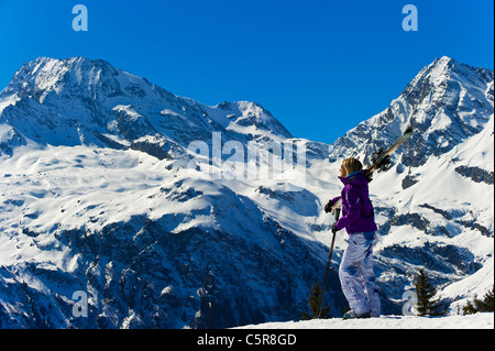 Eine Skifahrerin, genießen den herrlichen Schnee bedeckt die Berge Stockfoto