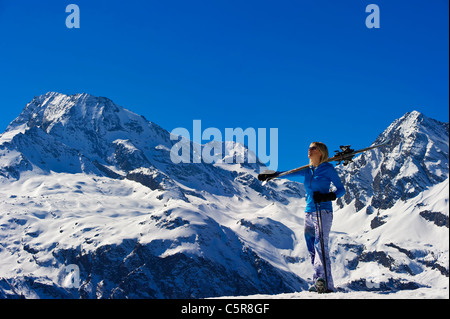 Eine Frau nimmt im Blick auf atemberaubende verschneite Berge. Stockfoto