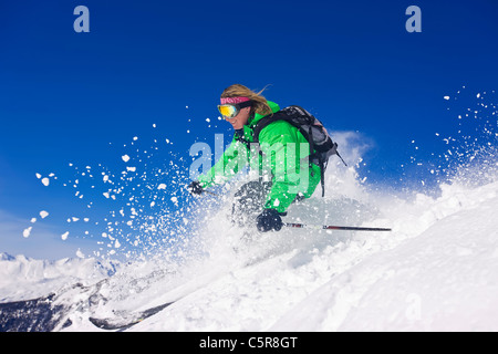 Ein Skifahrer Ski schnell durch verschneite Berge. Stockfoto