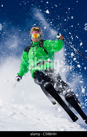 Ein Skifahrer explodiert durch den Pulverschnee. Stockfoto