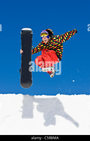 Ein Snowboarder springt von der Seite der Halfpipe in der Feier. Stockfoto