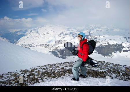 Ein Snowboarder blickt auf beeindruckenden schneebedeckten Bergen Stockfoto