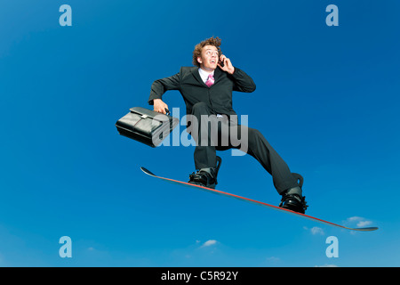 Ein Geschäftsmann Snowboarder auf Handy. Stockfoto