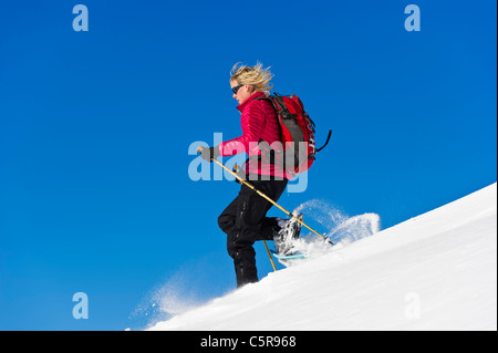 Schneeschuhwandern schnell hinunter Tiefschnee. Stockfoto