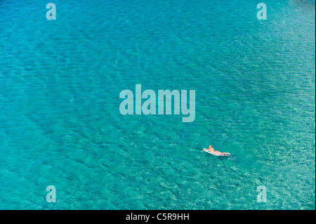 Eine Surfer paddelt ihr Board heraus auf den Ozean. Stockfoto