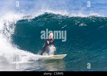 Surfer schnitzt eine brechende Welle Geschwindigkeit. Stockfoto