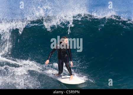 Surfer konzentriert sich, wie er entlang einer brechenden Welle schnitzt. Stockfoto