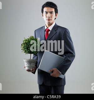 Ein Mann hält ein Blumentopf und einer Datei Stockfoto