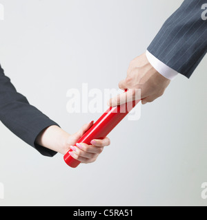 Eine Frau, die einen Stab mit einem Mann vorbei Stockfoto