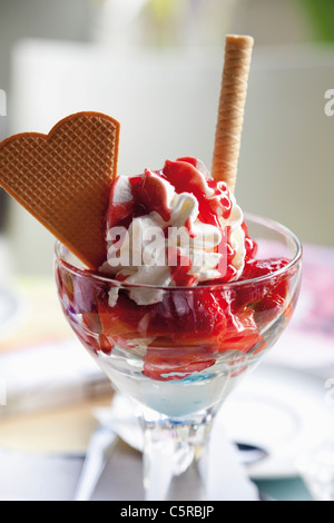 Nahaufnahme von Eis mit Schlagsahne und Herz-Form-Waffel Stockfoto