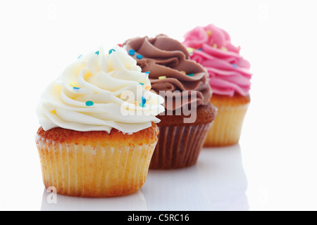 Nahaufnahme von Erdbeere, Vanille und Schokolade Buttercreme Cupcakes vor weißem Hintergrund Stockfoto