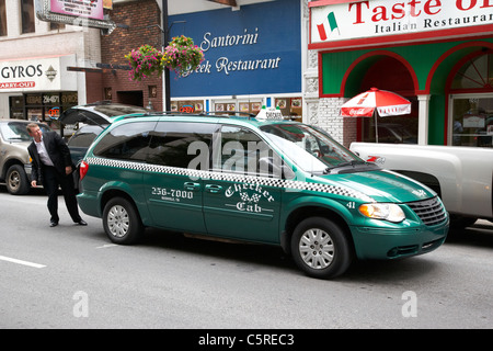 Mann Geschäftsmann laden Stamm der grünen Checker Taxi in der Innenstadt von Nashville Tennessee USA Stockfoto