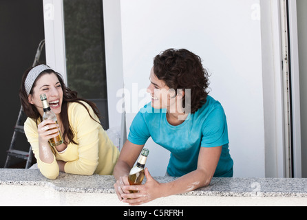 Deutschland, Köln, junges Paar Bier trinken in Wohnung Stockfoto