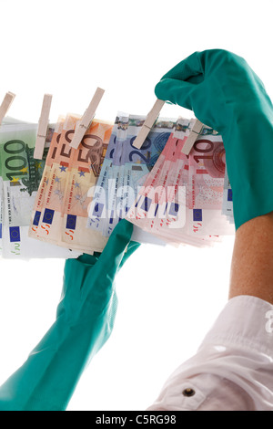 Person hängt von verschiedenen Euro-Banknoten auf der Wäscheleine, Nahaufnahme Stockfoto