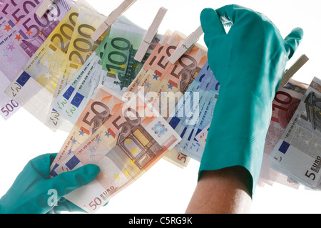 Person hängt von verschiedenen Euro-Banknoten auf der Wäscheleine, Nahaufnahme Stockfoto
