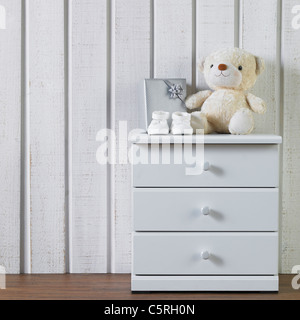 Baby Schuhe und andere Dinge auf einem Schrank Stockfoto