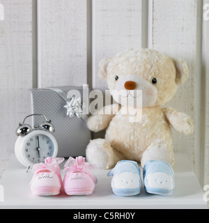 Baby Schuhe und andere Dinge auf einem Schrank Stockfoto