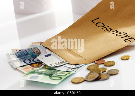 Lohn-Paket, Euro-Münzen und Euro-Banknoten, close-up Stockfoto