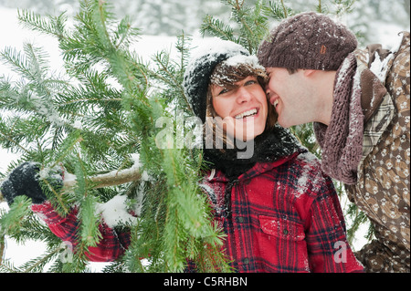 Österreich, Salzburger Land, Flachau, junger Mann und Frau mit Weihnachtsbaum Stockfoto