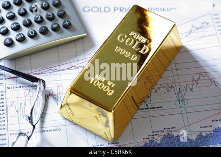 Goldbarren auf einem Aktien- und Aktiendiagramm Stockfoto