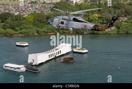 Ein SH-60F Sea Hawk-Hubschrauber fliegt über die USS Arizona Memorial in Pearl Harbor, HI Stockfoto