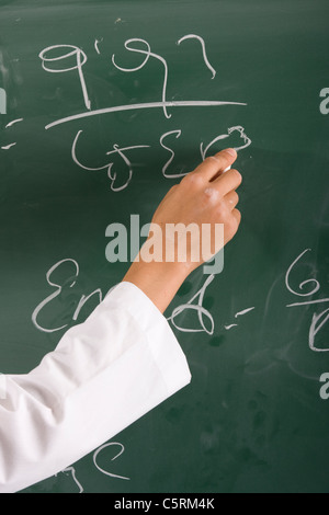 Lehrer ist auf Tafel schreiben. Stockfoto
