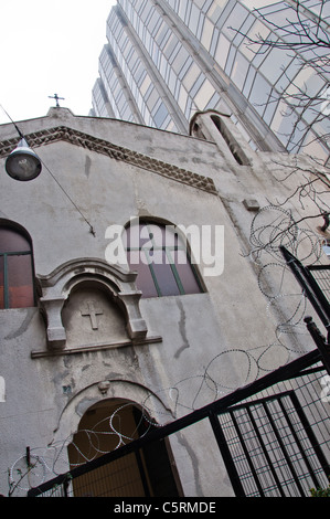 Eine Kirche mit Stacheldraht und einem Hochhaus, Istanbul, Türkei Stockfoto