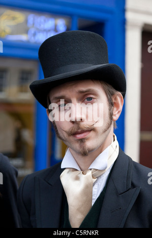 Ein Mann im viktorianischen Kleid steht auf Edinburghs Royal Mile zu seiner Show in das Fringe Festival zu fördern Stockfoto