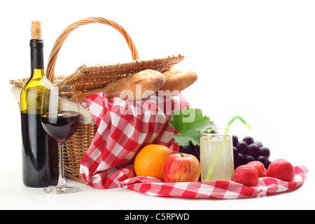 Picknick-Korb mit Früchten, Zitronensaft und Wein auf weißem Hintergrund. Stockfoto