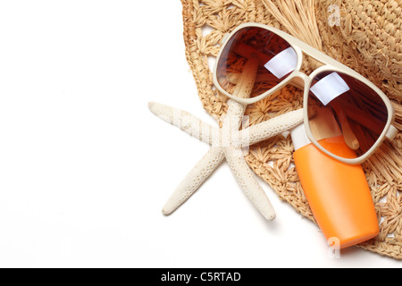 Sonnenbrille, Sonnencreme und Strohhut isoliert auf weißem Hintergrund. Stockfoto