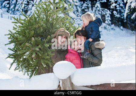 Österreich, Salzburger Land, Flachau, Blick auf Familie mit Weihnachtsbaum im Schnee Stockfoto