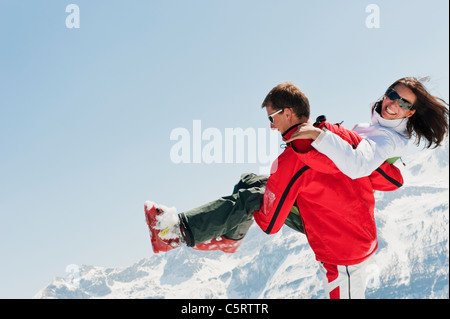Österreich, Salzburger Land, Altenmarkt-Zauchensee, Mitte erwachsenen Mann trägt Frau im winter Stockfoto